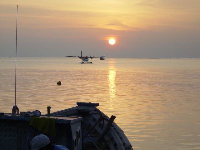 A Boat a plane and a sunset